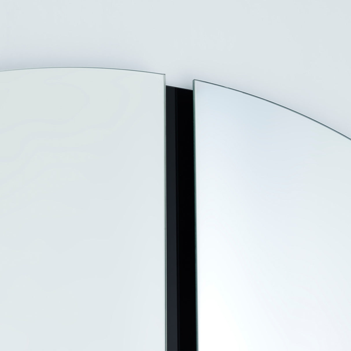 Close-up of the central joint, the two half moons meeting either side of a recessed strip of black lacquered glass.