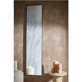 Travertin rectangular wall mirror with thin black metal frame and travertine-print glass, mounted on textured brown wallpaper beside a side table with candles.