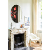 Museo Still Life Printed Round Wall Mirror 100cm, frameless circular glass mirror with a dark floral still life print on one side, mounted above a marble fireplace in a living room.