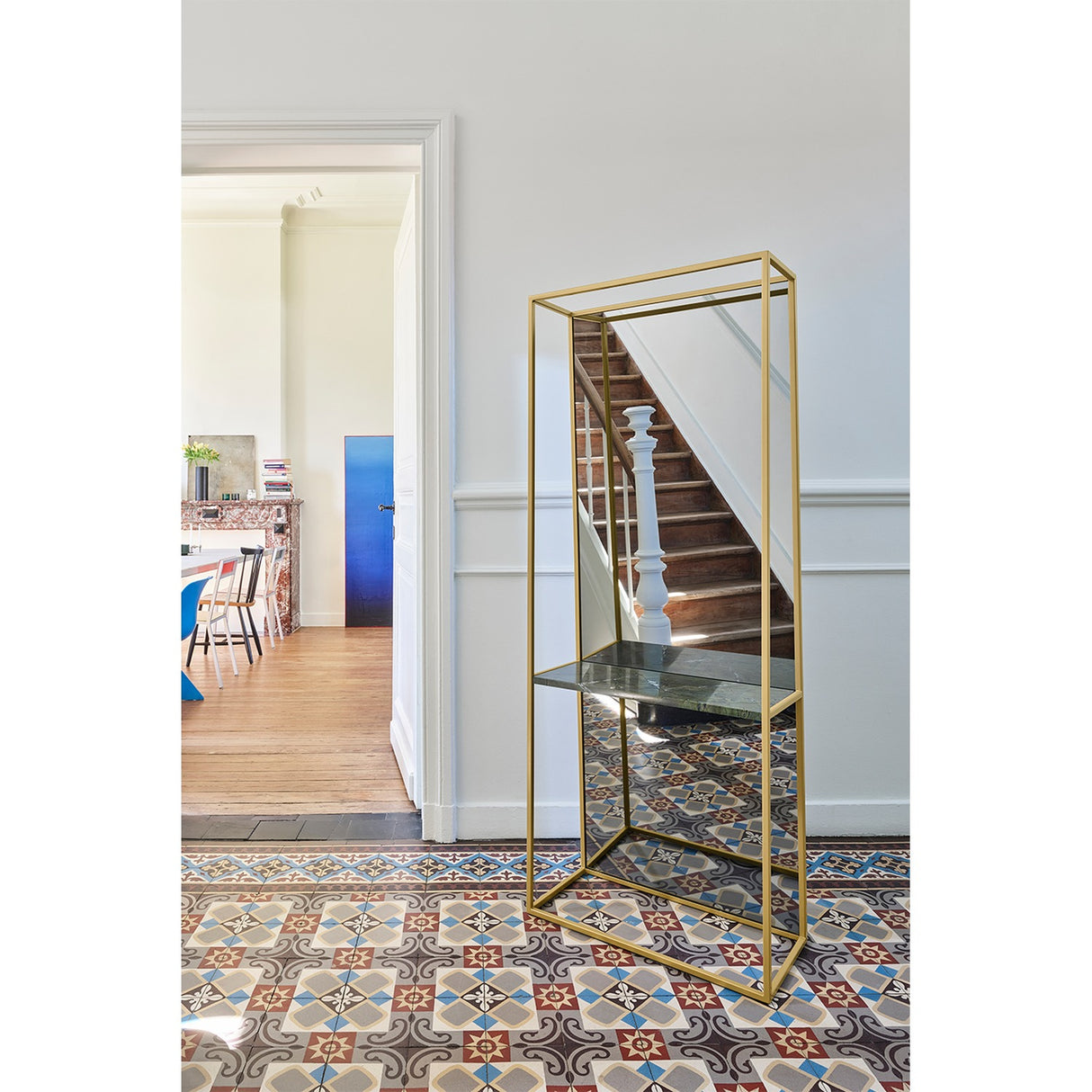 Chassis XL Deluxe free standing cheval mirror, 170cm, with open gold metal frame, green marble shelf, and mirrored panel, shown in a hallway beside a staircase.