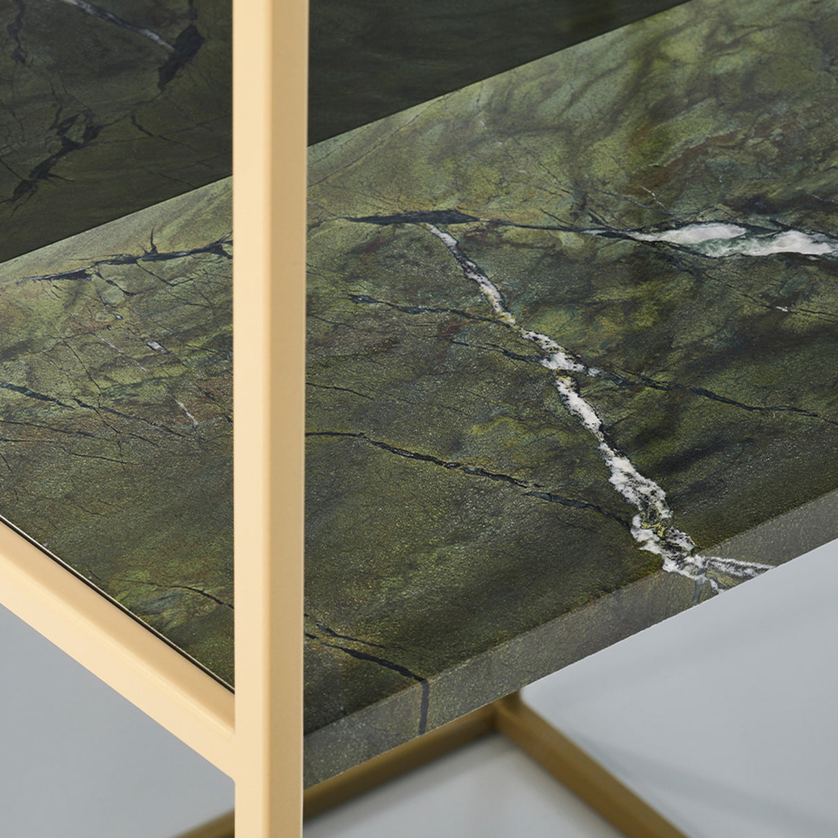 Close-up of the Chassis XL Deluxe free standing mirror's green marble shelf with white veining, set within an open gold metal frame.