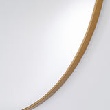 Close-up of the Hoop Bronze Round Wall Mirror 105cm, showing the thin bronze metal rim against the mirrored glass edge, set on a plain white wall.