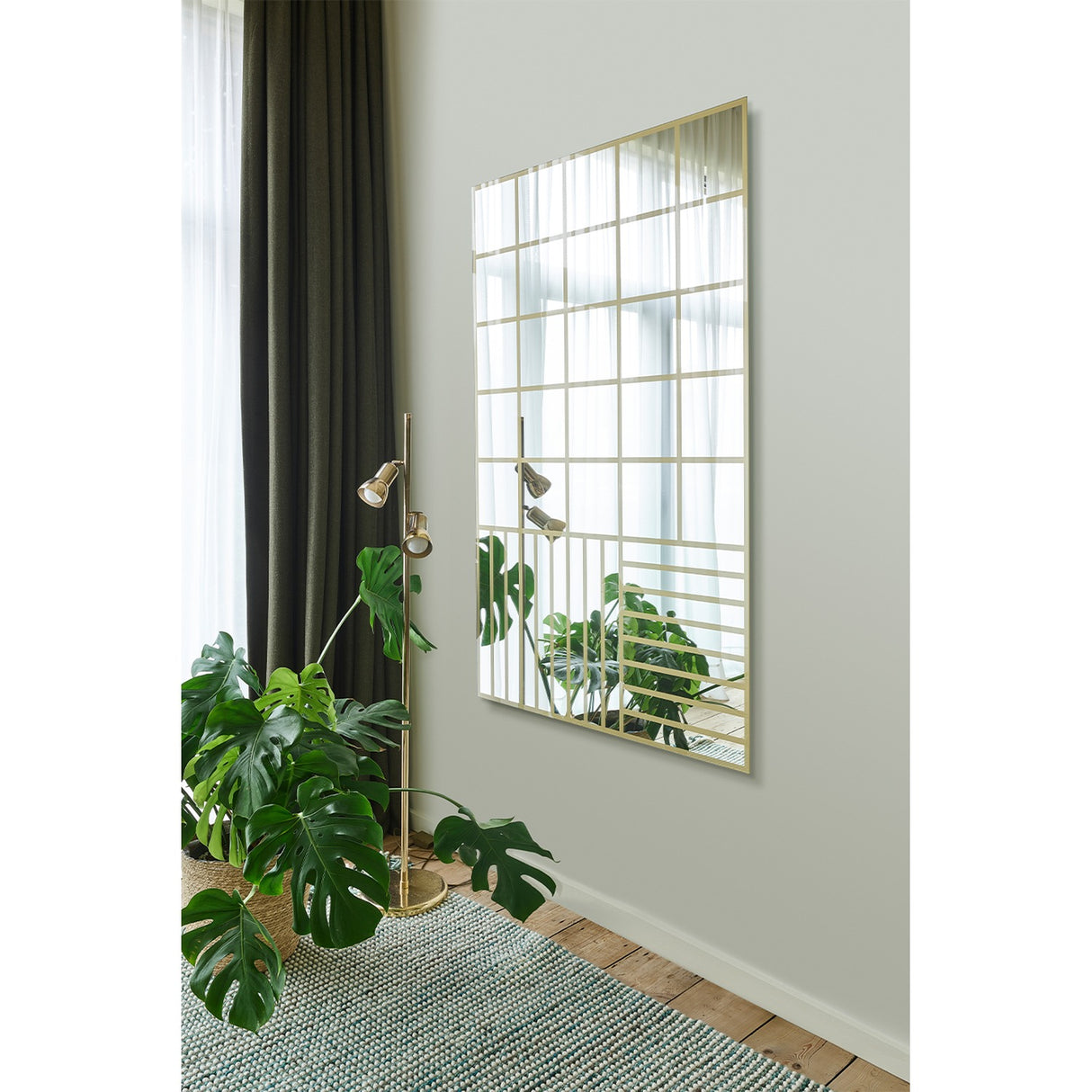 Grid Gold Window Print Full Length Mirror, 158cm rectangular glass mirror with gold grid print, wide squares above and finer stripes below, mounted on a wall beside a plant and floor lamp.