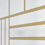 Close-up of the Grid Gold Window Print Full Length Mirror 158cm, showing gold grid lines printed on glass in varied panel widths against a soft white background.