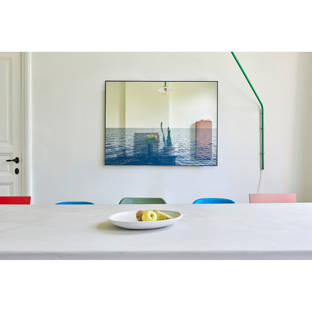 Maro Seascape Printed Glass Wall Mirror 120cm in a black rectangular frame, hung above a dining table, with mirrored sky above a printed blue seascape.