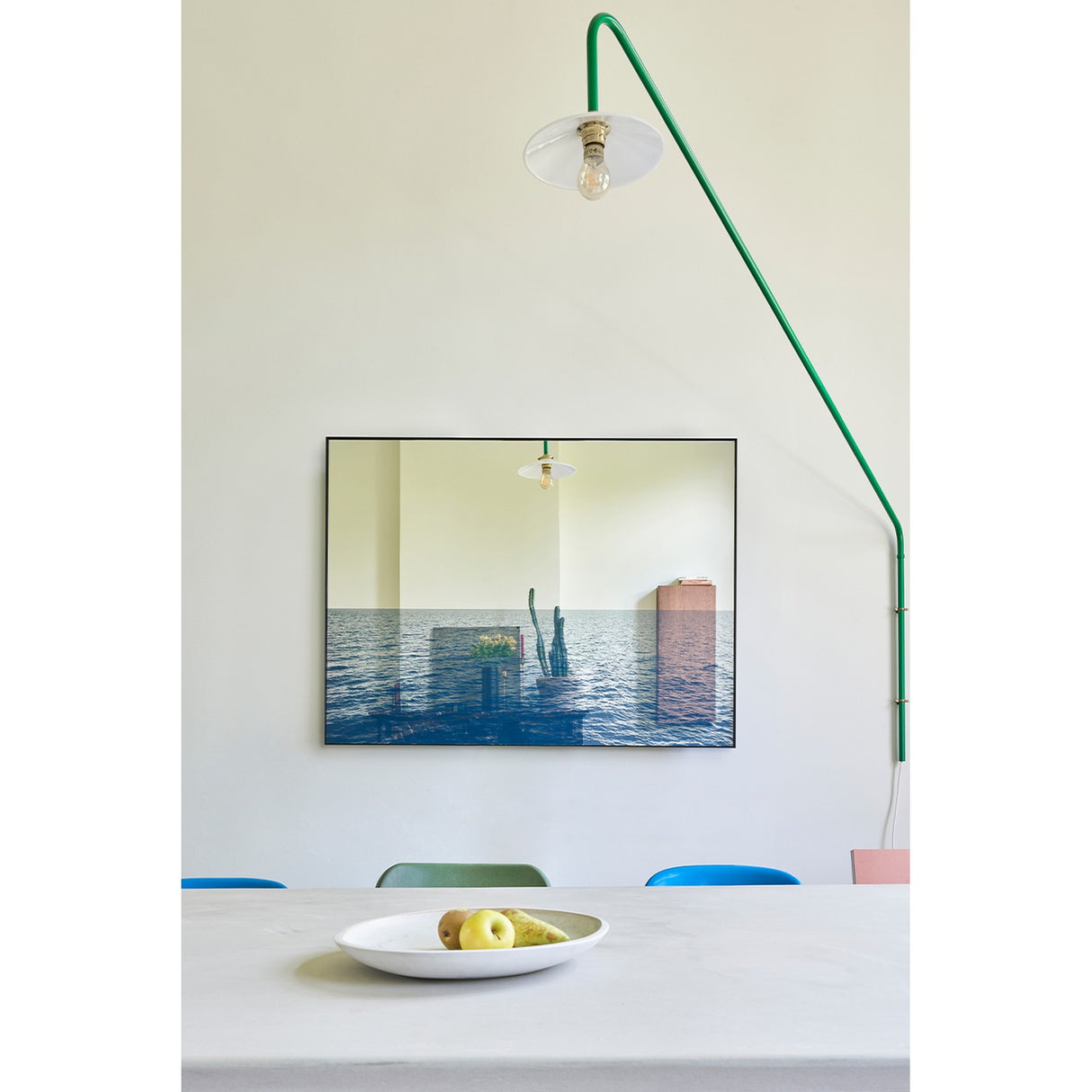 Maro Seascape Printed Glass Wall Mirror 120cm in a black rectangular frame, hung above a dining table, blending a printed seascape below with a mirrored surface above.