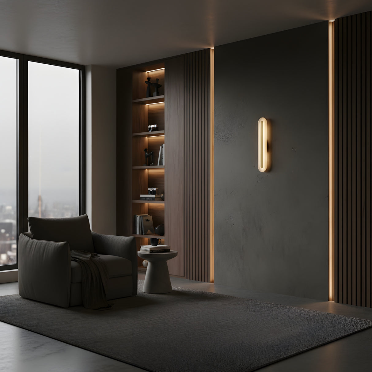 Minimalist living room with a large window, armchair, side table, dark accent wall featuring Averra LED Small Round Alabaster Wall Light in Soft White & Brass, built-in shelves with books and decor, city view, and a calm modern feel.