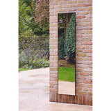 Lucka Outdoor Full Length Garden Mirror 175cm in black, slim metal frame, rectangular shape, mounted on a brick wall reflecting garden greenery and a paved patio.