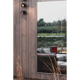 Lucka Outdoor XL Full Length Garden Mirror, 175cm rectangular design with slim black metal frame, mounted on wood cladding and reflecting an outdoor lounge and garden setting.