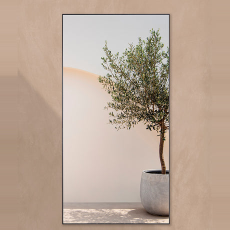 Lucka Outdoor XXL full-length garden mirror, 200cm rectangular black metal frame, mounted on a beige wall reflecting an olive tree in a grey planter.