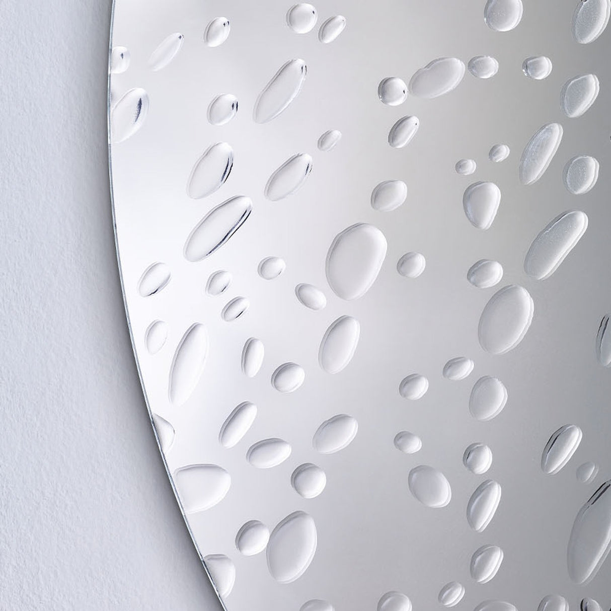 Close-up of the Matin 60cm round frameless wall mirror showing hand-applied raised dewdrop details scattered across the reflective glass surface.