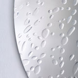 Close-up of the Matin 60cm round frameless wall mirror showing hand-applied raised dewdrop details scattered across the reflective glass surface.