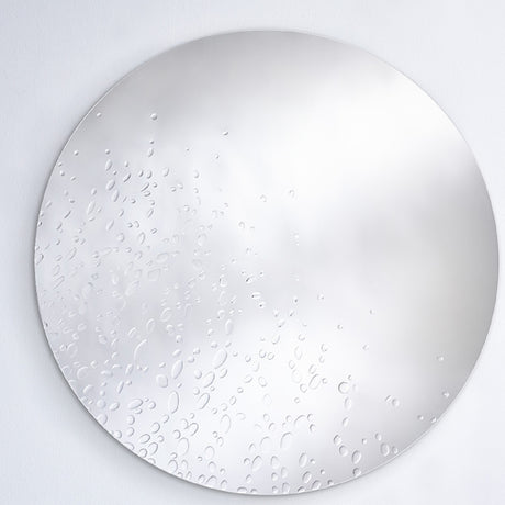 The dewdrop mirror seen larger, the drops gathered more thickly to one side and thinning across the face.