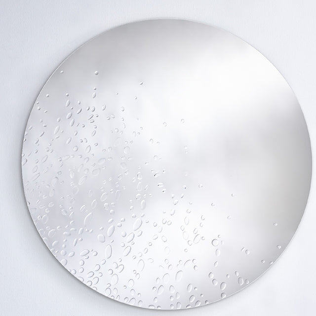 The dewdrop mirror seen larger, the drops gathered more thickly to one side and thinning across the face.