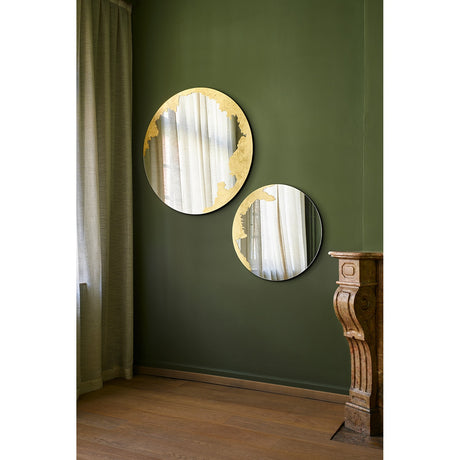 Ornato Gold Leaf Round Rotating Wall Mirror 70cm shown in pairs on a green wall, each frameless round mirror with an irregular hand-applied gold leaf patch on the rim.