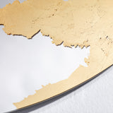 Close-up of the Ornato Gold Leaf Round Rotating Wall Mirror 70cm, showing hand-applied gold leaf with a torn, irregular edge against the plain mirror surface.