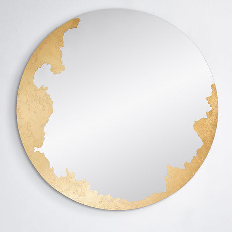 The gilded round mirror seen straight on, the hand applied gold leaf gathered down one side of the glass.