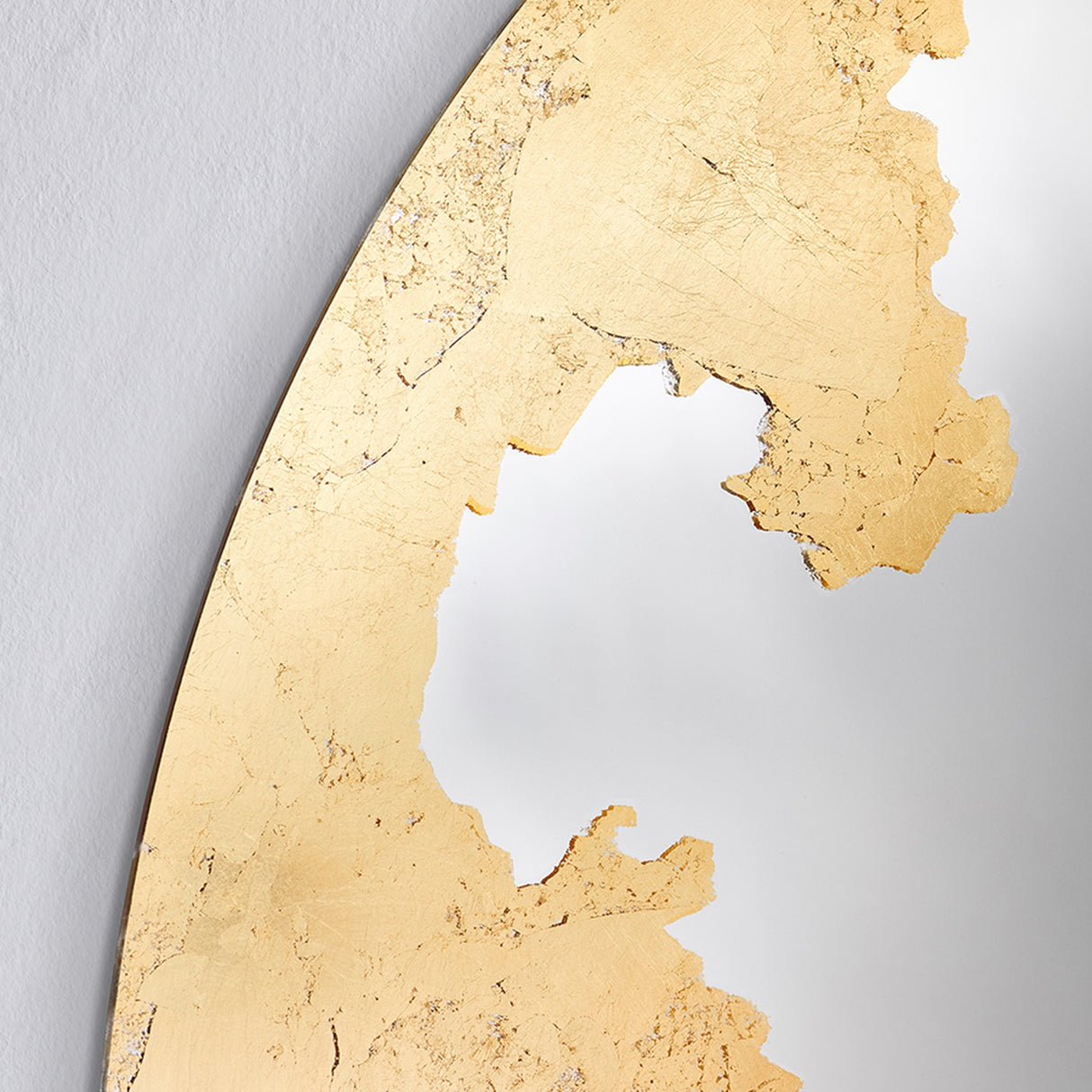 Close-up of the torn edge of the gold leaf, laid by hand so the border breaks like a coastline.