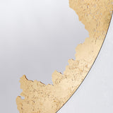 Close-up of the gilding meeting the plain glass, the leaf thinning to broken flecks along the join.