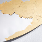 Close-up of the gold leaf surface, the crazing and overlaps of the individual sheets visible across it.