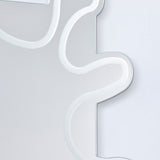 Close-up of the Wiggle Scalloped Edge Wall Mirror 133cm, showing the frameless glass edge with its wavy outline and engraved border line against a plain wall.