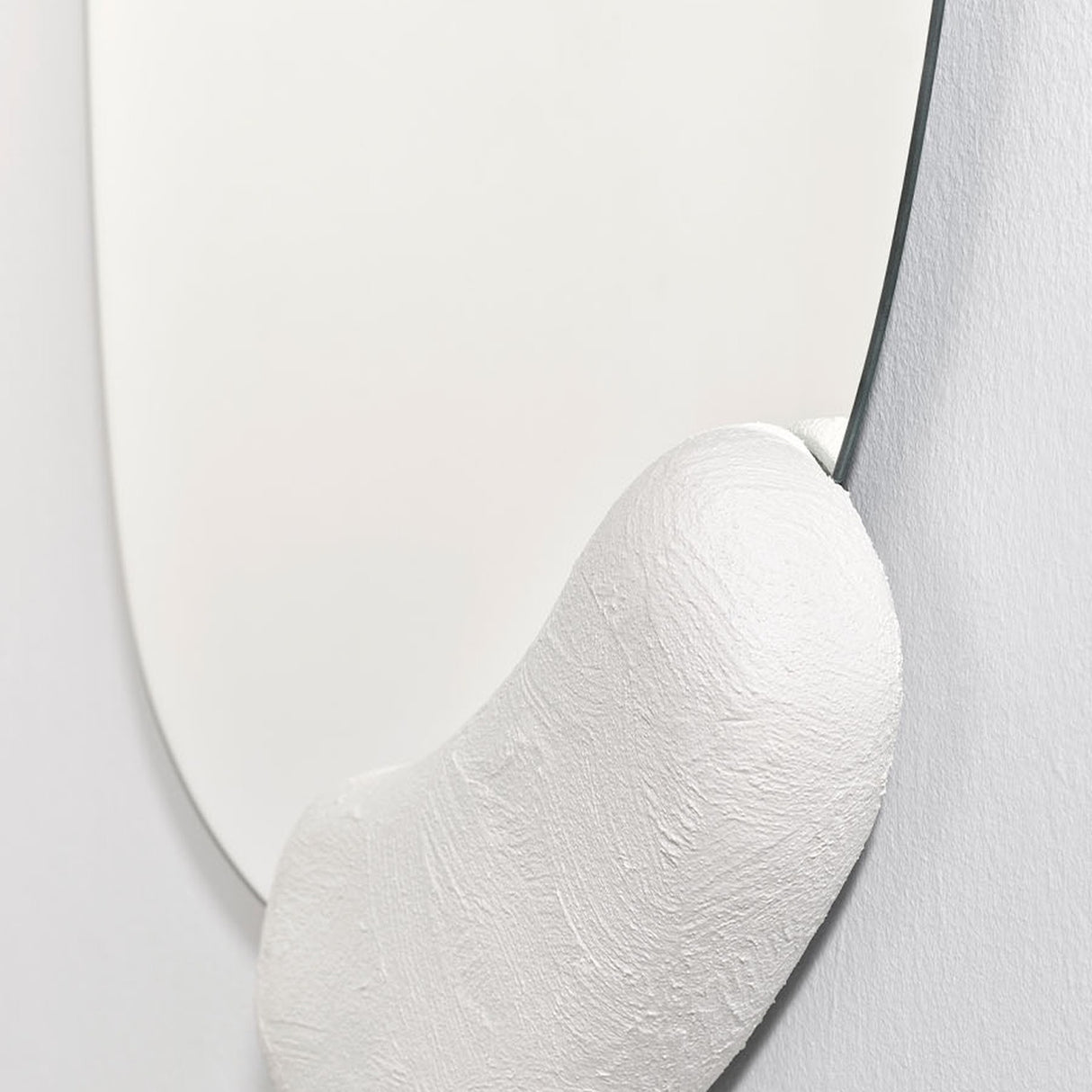 Calco White Sculpted Round Wall Mirror 73cm, close-up of the hand-finished white moulded form against the round mirror's edge, showing visible brush texture.