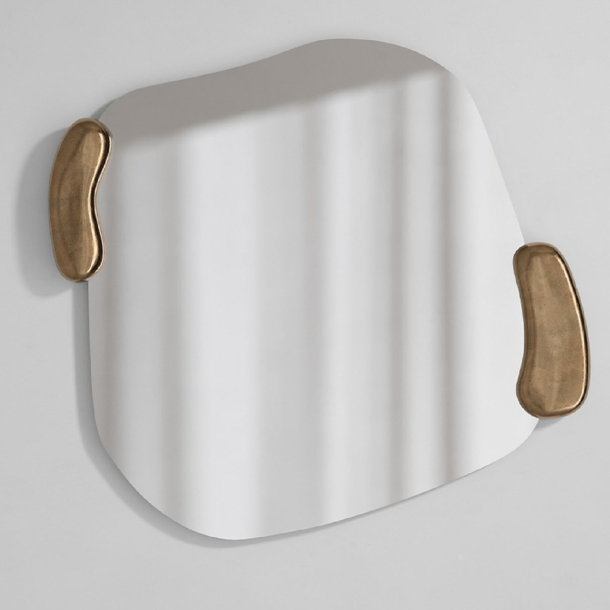 Calco Gold Leaf Sculpted Wall Mirror 116cm with an irregular frameless glass panel and two organic gold leaf handle-like forms at the edges, shown on a plain white background.