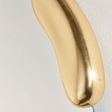 Close-up of the Calco Gold Leaf Sculpted Wall Mirror 116cm, showing the smooth, curved gold-leaf frame with an irregular organic shape against a plain light background.