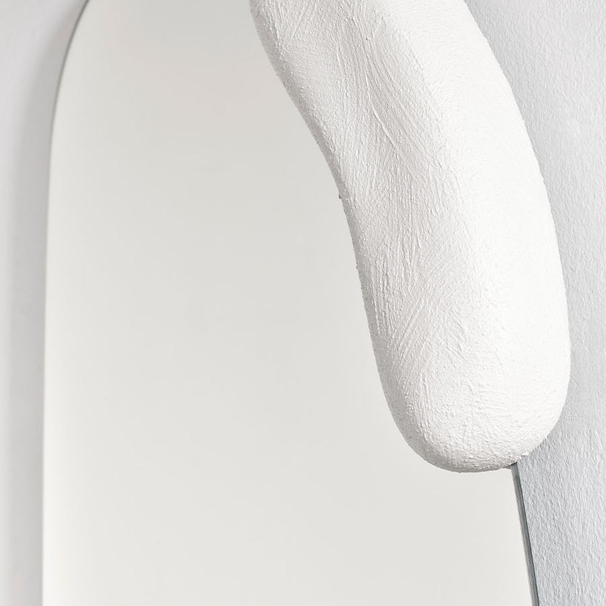 Close-up of the upper moulded form, its hand worked surface set against the curved edge of the glass.