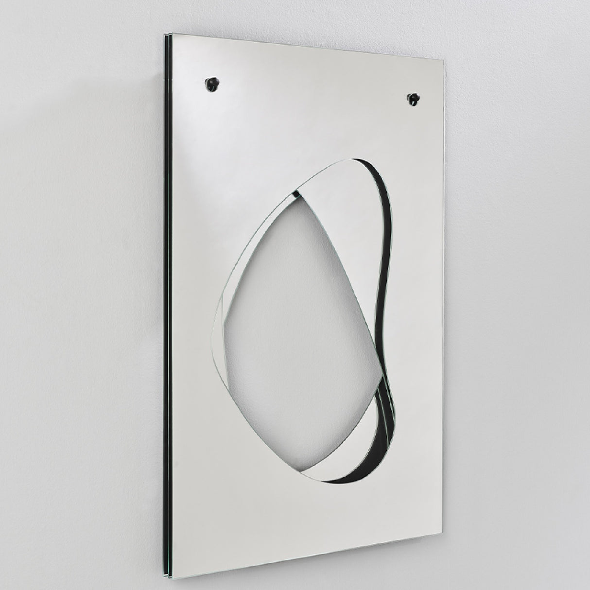 Infinito Precision Cut Void Wall Mirror 100cm, rectangular white panel with an organic cut-out void revealing recessed mirror layers, mounted on a plain wall, shown at an angle.