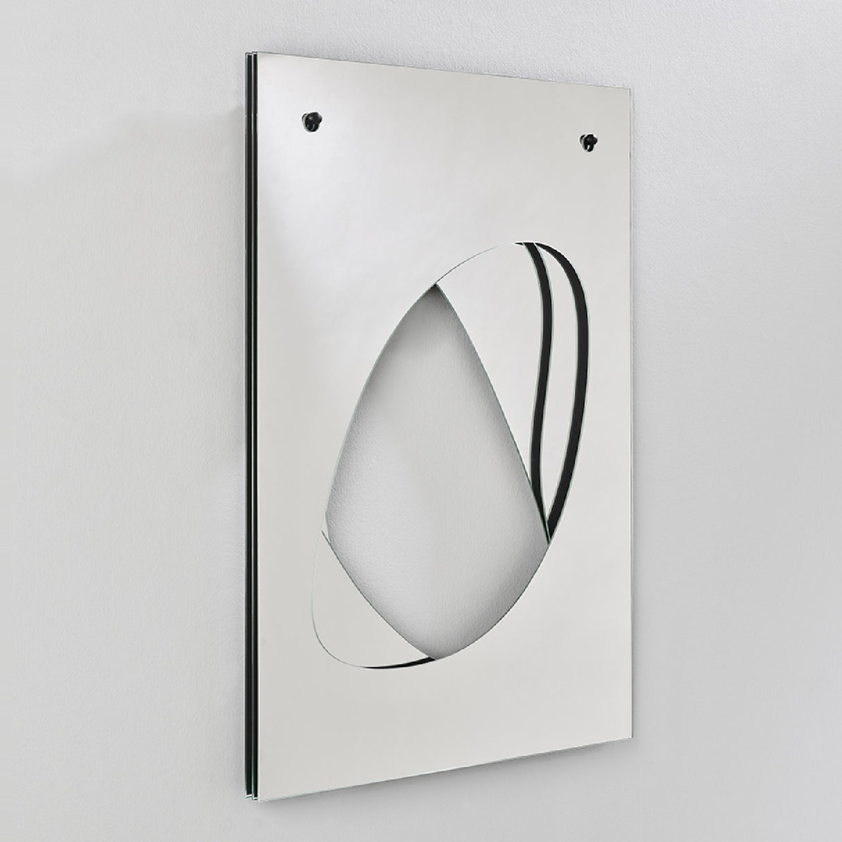 Infinito Precision Cut Void Wall Mirror 100cm shown at an angle, a rectangular white panel with an organic cut-out void revealing layered mirror glass beneath, against a plain light background.