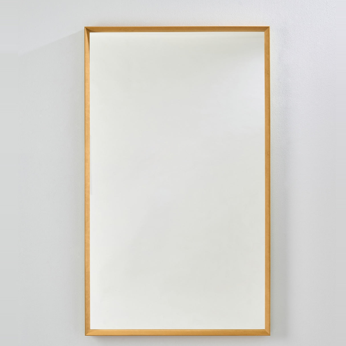 Rectangular wall mirror with a deep ochre velvet box frame and recessed glass, mounted on a plain light grey wall.