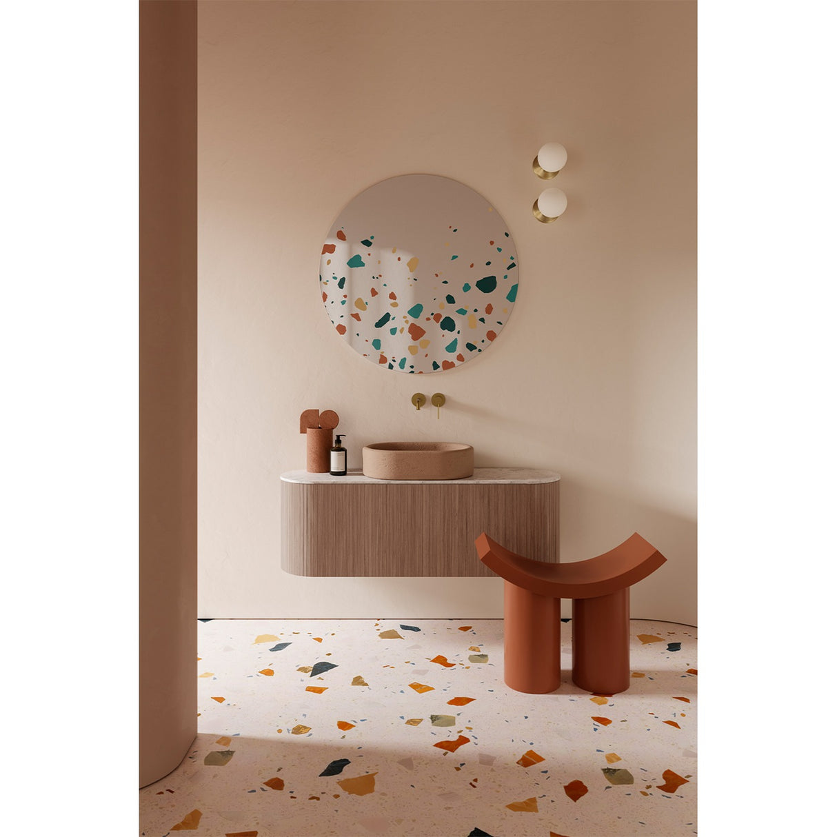 Terrazzo Round Printed Glass Wall Mirror 100cm, frameless circular design with multicoloured terrazzo chips at the lower edge, mounted above a wall-hung vanity in a bathroom setting.