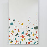 Frameless rectangular glass wall mirror, 120cm, with red, teal, ochre and grey terrazzo print along the lower edge and a plain mirror surface above.