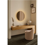 Brio Bronze round wall mirror with warm white LED backlighting, frameless bronze mirrored glass, mounted above a wood dressing table in a living space.
