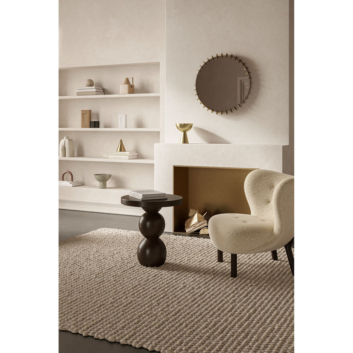 Ray Gold round wall mirror, 65cm, with interlocking gold metal discs framing the edge, shown above a fireplace in a living room setting.