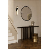 Ray Black Powder Coated Round Mirror with radiating metal spoke frame, hung above a dark console table in a hallway with a wall light and staircase.