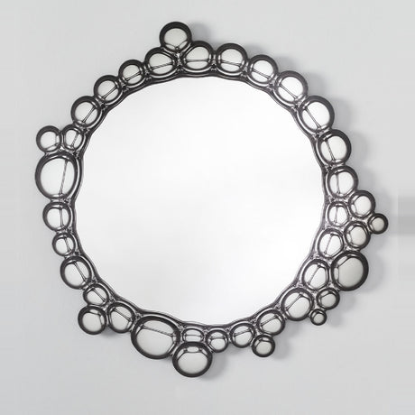 The bubble ringed mirror seen straight on, the circles varying in size around the whole of the glass.