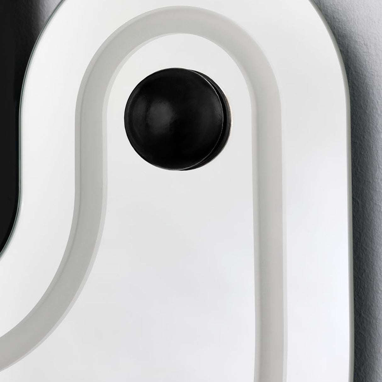 Close-up of a sphere seated on its raised track, the white moulded surround curving closely around it.