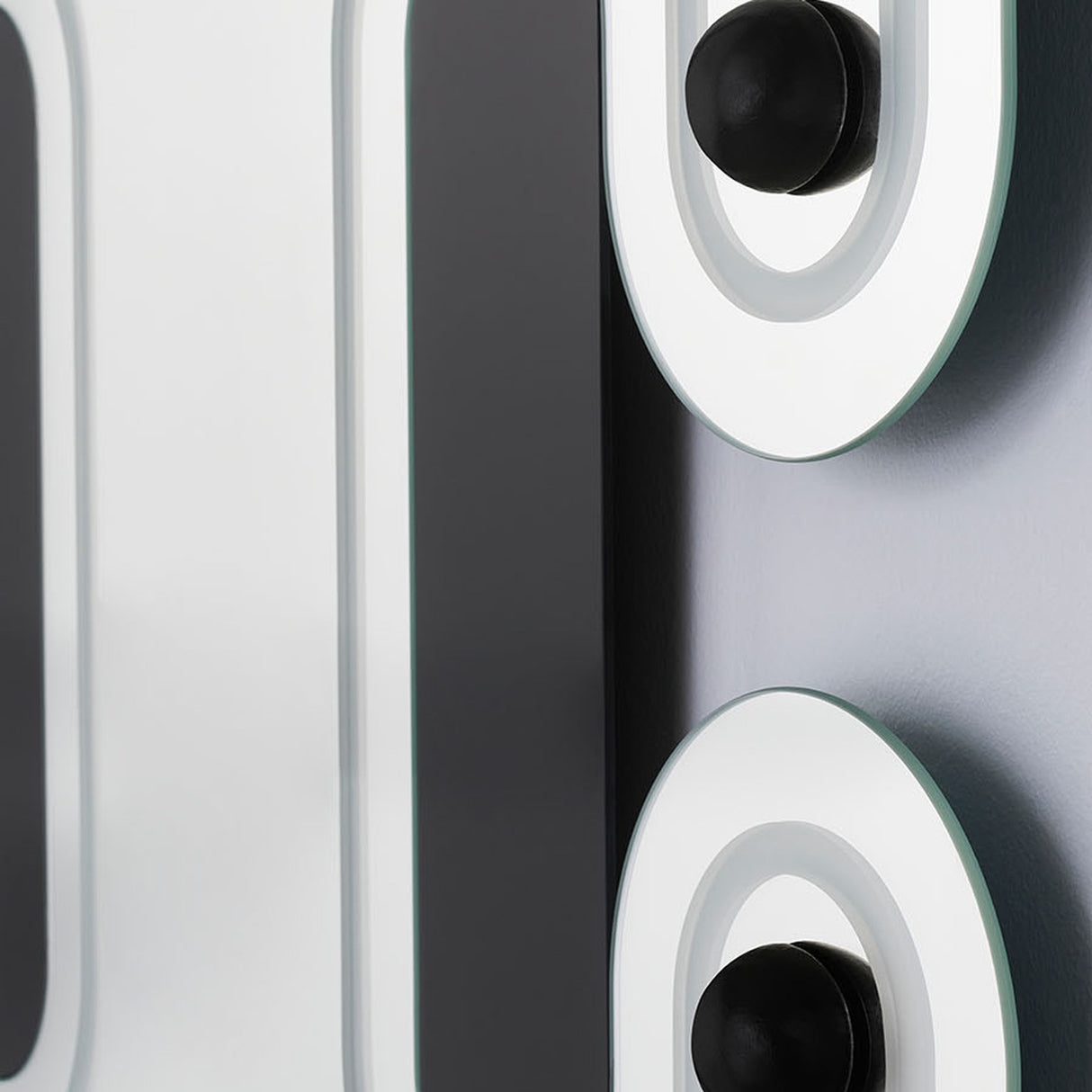 Close-up of two spheres and the engraved slots, the tracks running between them across the glass.