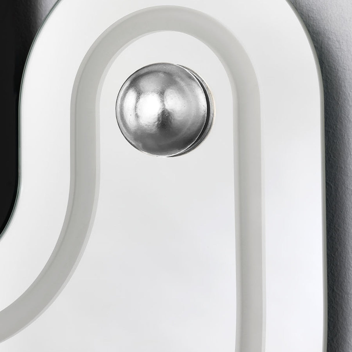 Close-up of the Satellite Silver Leaf Engraved Orbit Wall Mirror, showing a silver metal leaf sphere set into an engraved curved path on the mirrored surface.