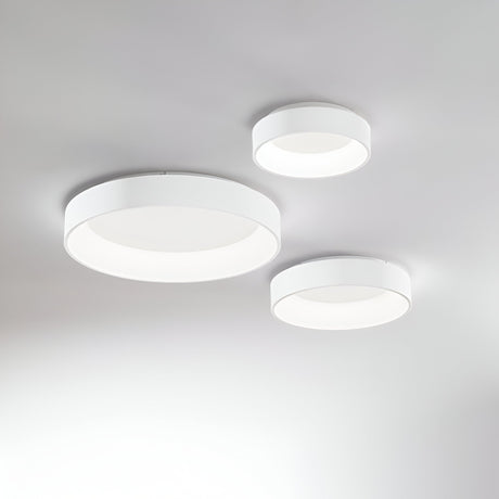 Three Fluxis LED Flush Ceiling Lights in white, measuring 45cm each, are arranged on a plain white ceiling. These modern, round lights vary in size and form a triangular pattern, providing a soft, diffused glow with energy-efficient illumination.