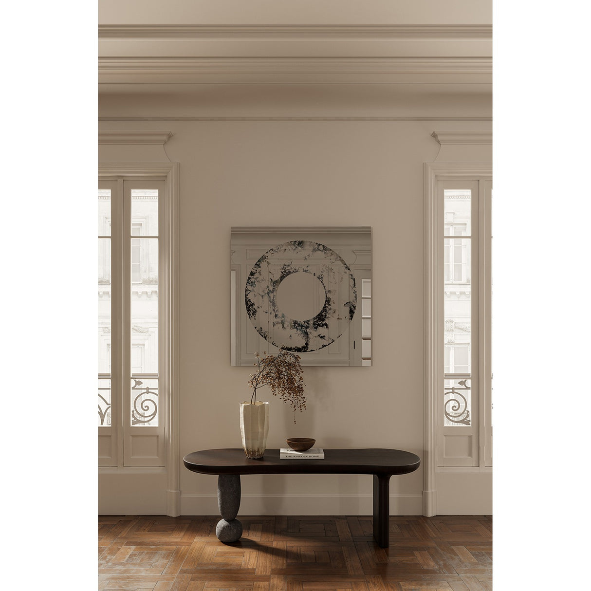 Torus Hand Silvered Square Wall Mirror 100cm with a mottled black, grey and brown ring around a clear centre, hung above a dark console table in a hallway.