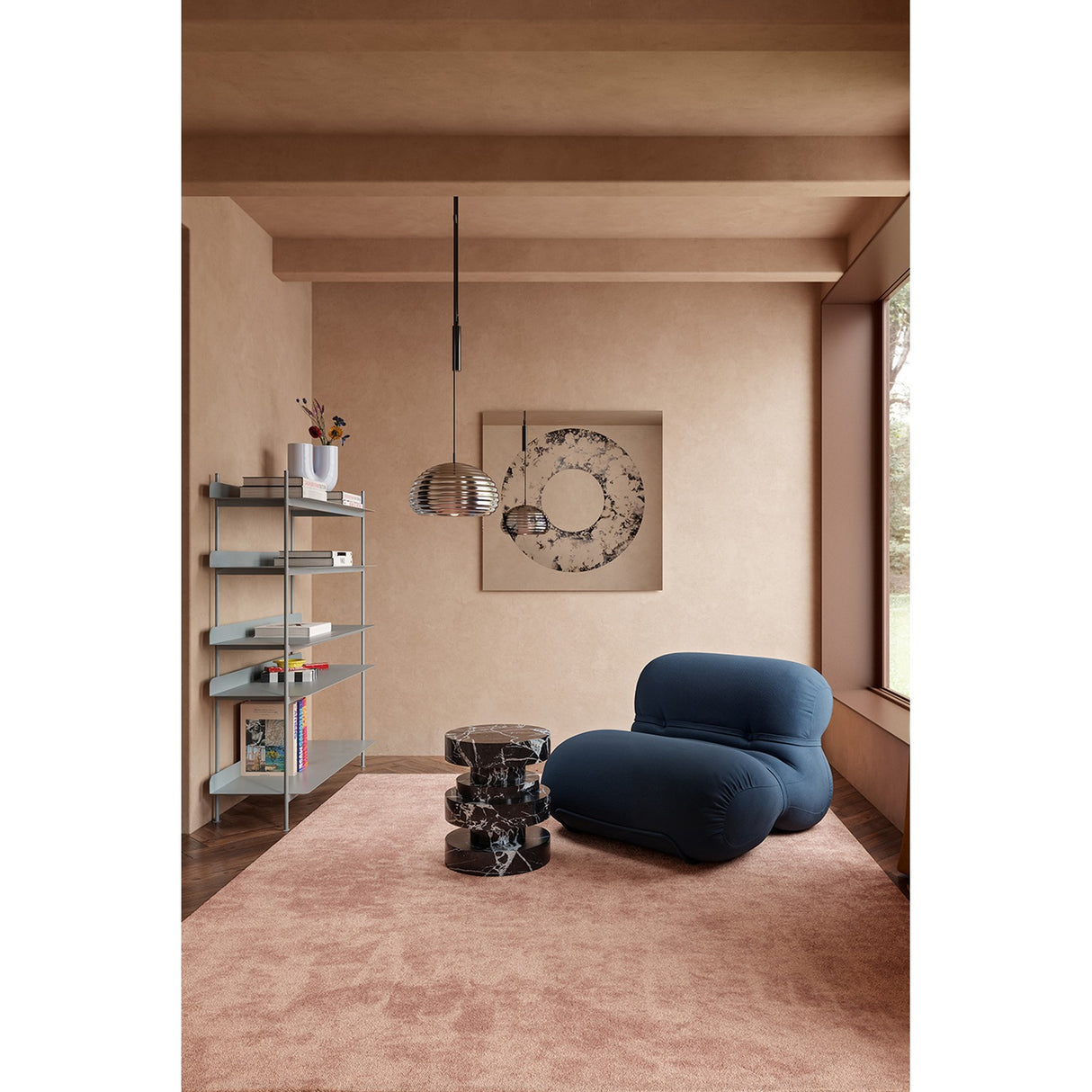 Torus Hand Silvered Square Wall Mirror 100cm hung above a bookshelf in a living room, its round mirrored ring showing clouded silver, grey and black patterning around a plain glass centre.