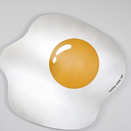 The egg shaped mirror seen at a shallow angle, the printed yolk and its single highlight catching the light.