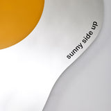 Close-up of the words sunny side up printed small along the curved white edge of the glass.