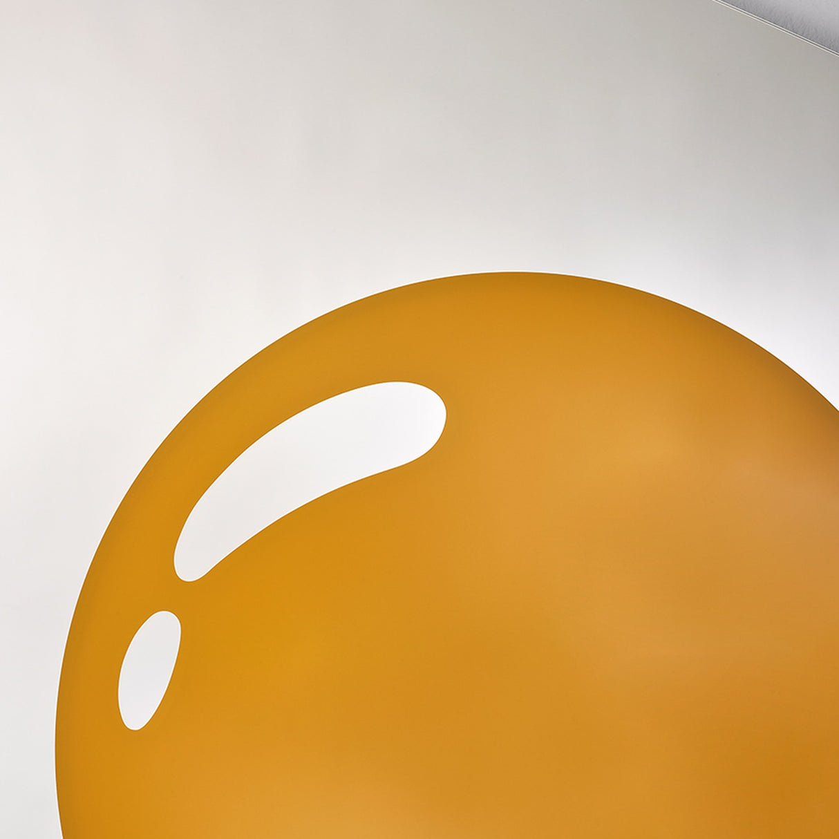Close-up of the printed yolk, a flat disc of deep yellow with a single bright highlight across it.