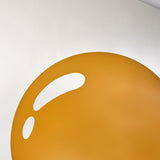 Close-up of the printed yolk, a flat disc of deep yellow with a single bright highlight across it.