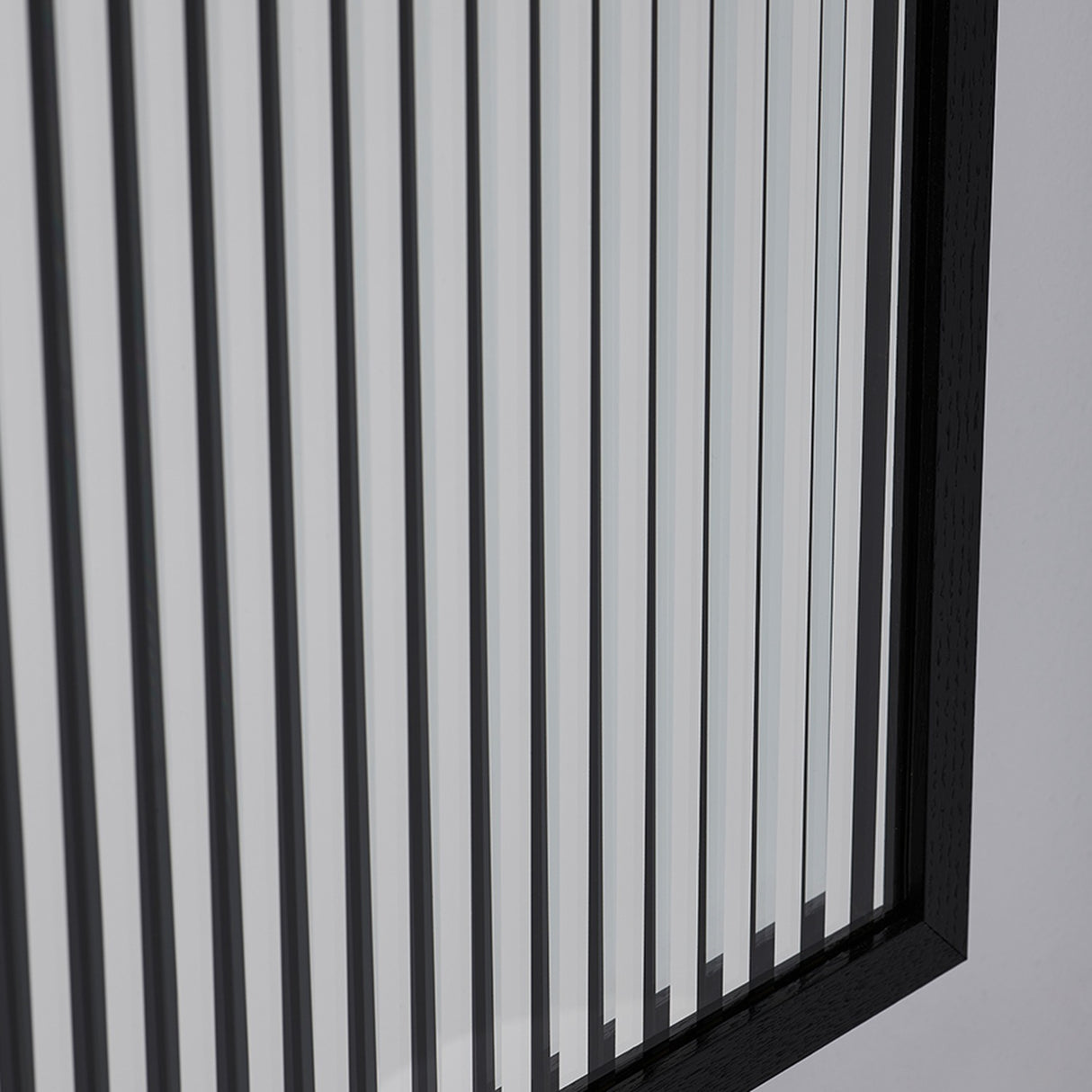 Close-up at an angle where the two layers of strips slide out of register, with the frame corner behind.