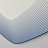 Close-up of the Vibe Blue Line Print Irregular Wall Mirror 80cm, showing concentric blue lines printed on glass, crowding tightly around a curved corner for a layered depth effect.